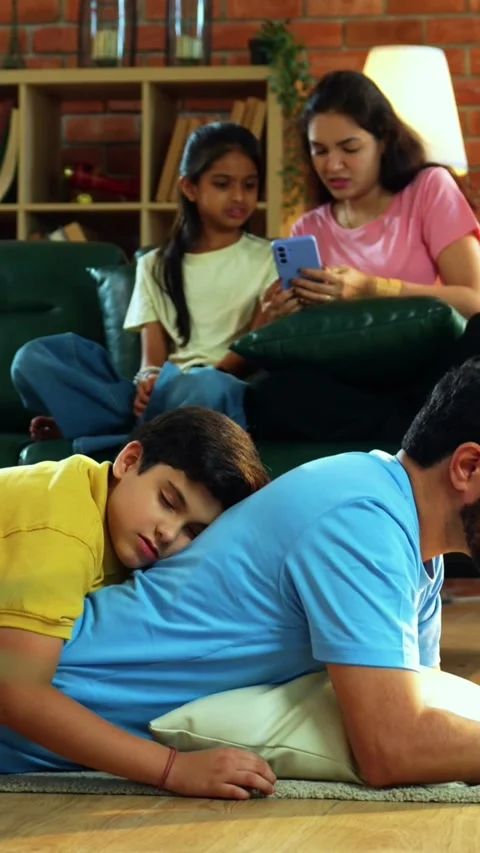 Father working son sleeping on back, wife and daughter browse phones Stock-Footage 342499692