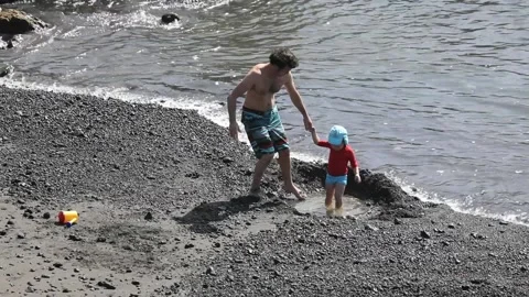 Father with a young son playing on the beach. Stock Footage 107697236