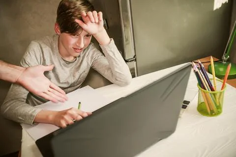 The father's hand indicates errors in learning. The boy does assignments from an Stock Photos