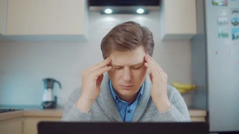 Fatigue at the computer. A man working at home in the kitchen Stock Footage 148343929