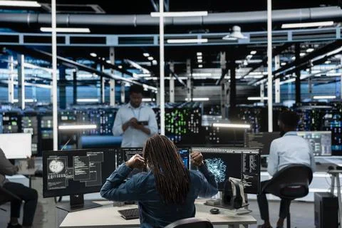 Fatigued data center admin stretching at desk, using machine learning algorithms 스톡 사진