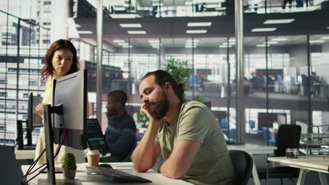 Fatigued software engineer caught asleep at desk by manager Stock Footage 318161449