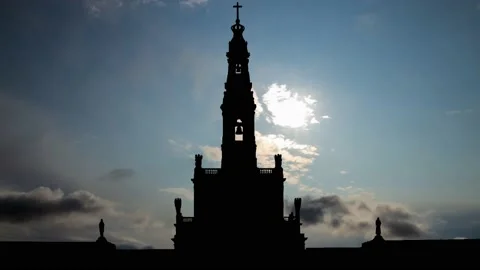 Fatima: Time Lapse at Sunrise with Fast Clouds and Dark Silhouette of Bell Tower Stock Footage 130586726