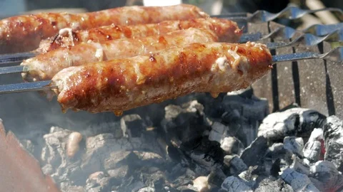 Fatty appetizing sausages cook on fire. Fat drips into the fire. A lot of smoke Stock Footage 78530335
