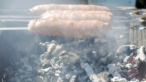 Fatty appetizing sausages cook on fire. Fat drips into the fire. A lot of smoke Stock Footage 78532935