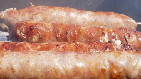Fatty appetizing sausages cook on fire. Fat drips into the fire. A lot of smoke Stock Footage 78537499
