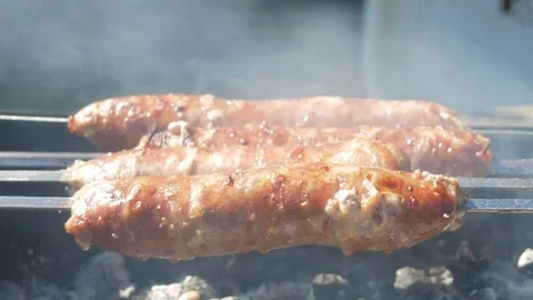 Fatty appetizing sausages cook on fire. Fat drips into the fire. A lot of smoke Stock Footage 78548426