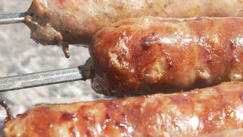 Fatty appetizing sausages cook on fire. Fat drips into the fire. A lot of smoke Stock Footage 78550478