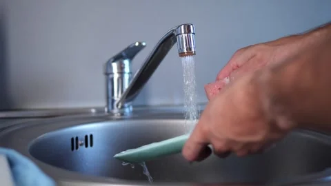Faucet and hands close-up man washing plate under running water. Observe the Stock Footage 278732966