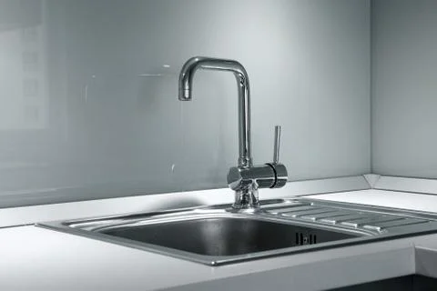 Faucet and sink in the kitchen Stock Photos