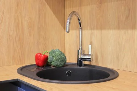 Faucet and sink in the kitchen Stock Photos