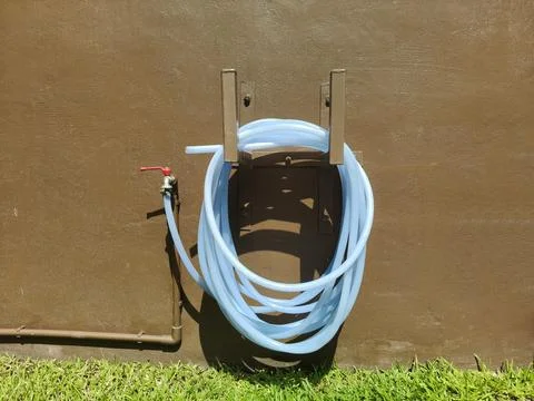 The faucet attached to the hose has a ring fixed to the wall. Foto stock
