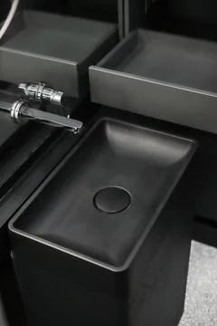 Faucet with black ceramic sink close-up in the bathroom Stock Photos