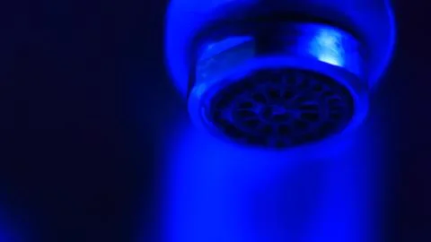 Faucet close up in dark environment Stock Photos