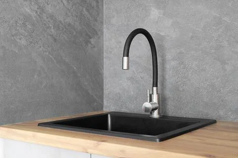 Faucet with granite sink in the kitchen Stock Photos
