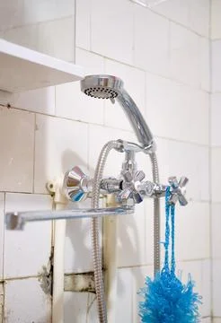 Faucet in an old bathroom, interior of a poor apartment. Plumbing repair Stock Photos