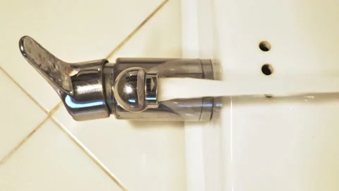 The faucet is opened, water flows into the drain basin, then was closed. Pouring Stock Footage 150176504