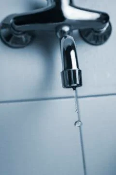 Faucet or kitchen tap leaking with water drops 스톡 사진