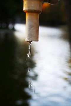 A faucet in the park from which dripped splashes of water Stock Photos