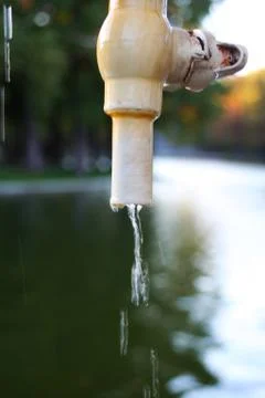 A faucet in the park from which dripped splashes of water Stock Photos