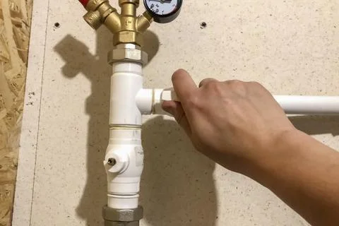 Faucet on a plastic heating pipe coming out of boiler Stock Photos