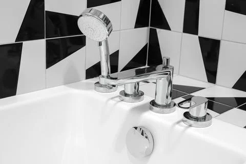 Faucet with shower head close-up over bathtub Stock Photos