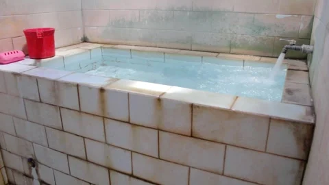 The faucet turns on to fill the ceramic bathtub to the brim Stock Footage 318945141