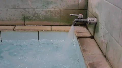 The faucet turns on to fill the ceramic bathtub to the brim Stock Footage 318945151