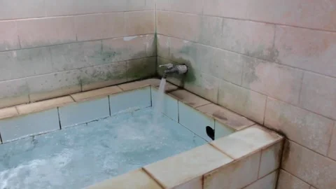 The faucet turns on to fill the ceramic bathtub to the brim Stock Footage 318945159