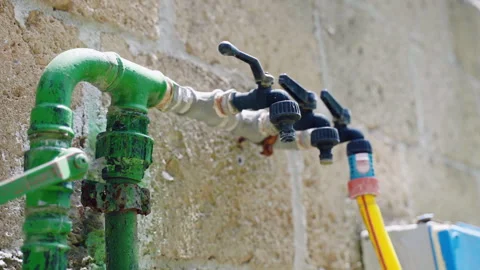 Faucets installed in the wall with attached pipe for watering garden Stock Footage 288453620
