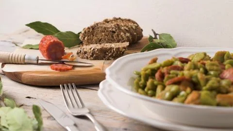Favas com chourio and rustic bread on a weathered wooden table Stock Photos