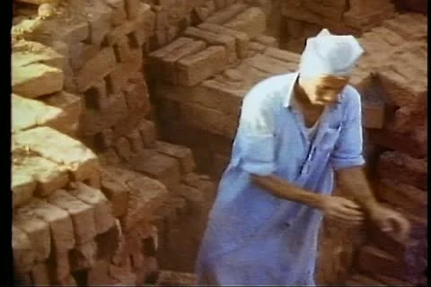 FAYOUM OASIS, EGYPT, 1977, Brigade of men tossing bricks to each other Stock Footage 10738813