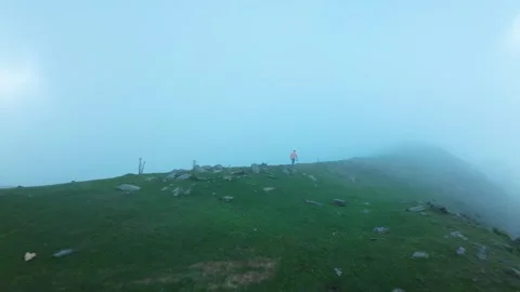 FB shot behind a man in high mountains in fog and clouds Video stock 252071962