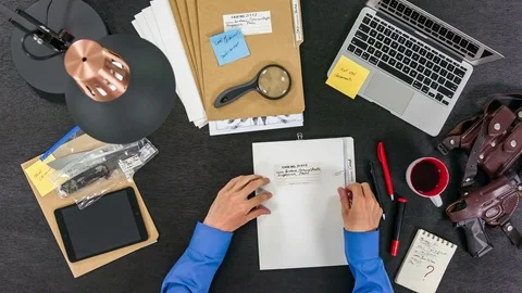 The FBI agent examines the criminal case, photographs and evidence. Top view Stock Footage 80214786