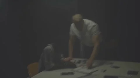FBI Agent Interrogates Handcuffed Suspect in Dark Room Stock Footage 320030025