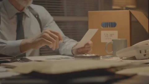FBI Agent Smoking While Reviewing Crime Scene Photos at Desk Stock Footage 321985386