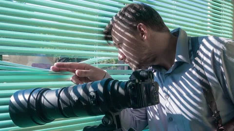 FBI agent spying and looking through blinds near SLR camera Vídeo Stock 97563677