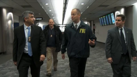 FBI agents and Homeland Security walk through an airport. Stock Footage