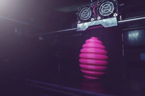 FDM 3D-printer manufacturing wound pink easter egg sculpture - wide angle vie Stock Photos