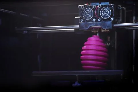 FDM 3D-printer manufacturing wound pink easter egg sculpture - front view on  Stock Photos