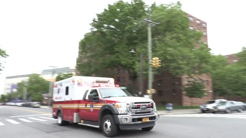 FDNY ambulance with siren passing in street Stock Footage