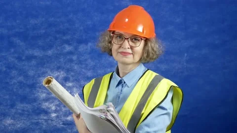 Feamle Engineer in the construction helmet and yellow vest with mobile phone  Stock Footage 166857544