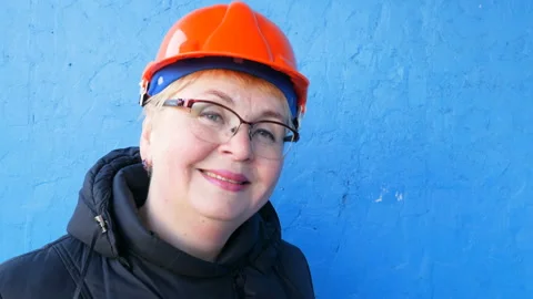 Feamle Engineer in the construction helmet on blue background Stock Footage 147438866