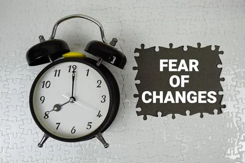 Fear Of Changes text with alarm clock on gray background Stock Photos