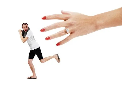 Fear of commitment. A young man trying to run away from a giant hand wearing  Stock Photos