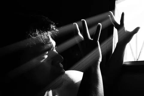 Fear man alone in the dark with light from window Photos