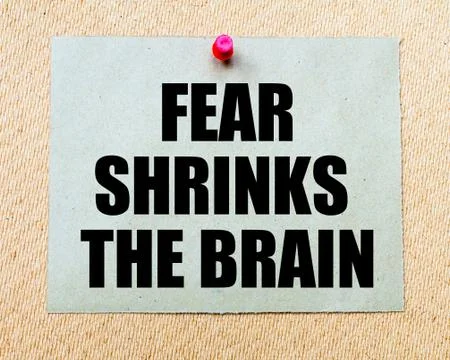 Fear Shrinks The Brain written on paper note pinned with red thumbtack Stock Photos
