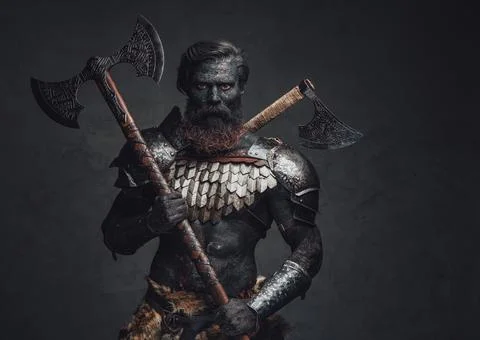 Fearful and muscular warrior with scorched skin and double axe Stock Photos