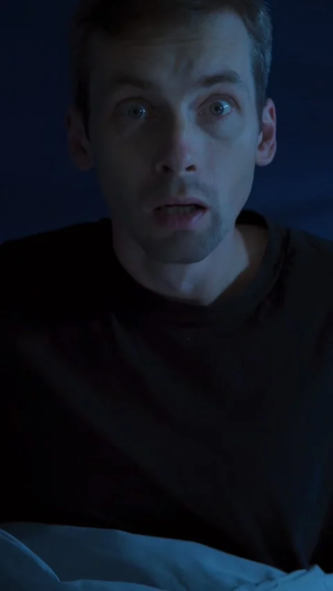 Fearful man suddenly wakes up in a panic attack. Sleep disorder and night terror Video stock 322780326