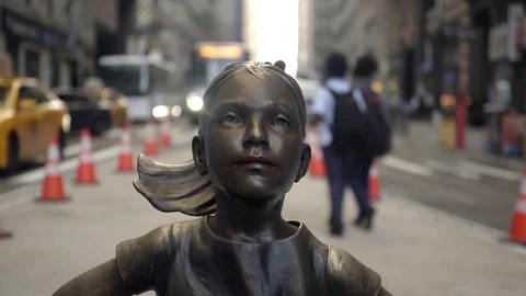 Fearless Girl statue stares down the charging bull of Wall Street. 4K UHD. Stock Footage 76973570